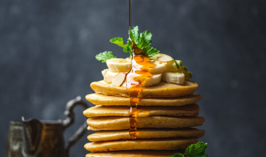 A picture of baked pancakes with honey sprinkled on top.